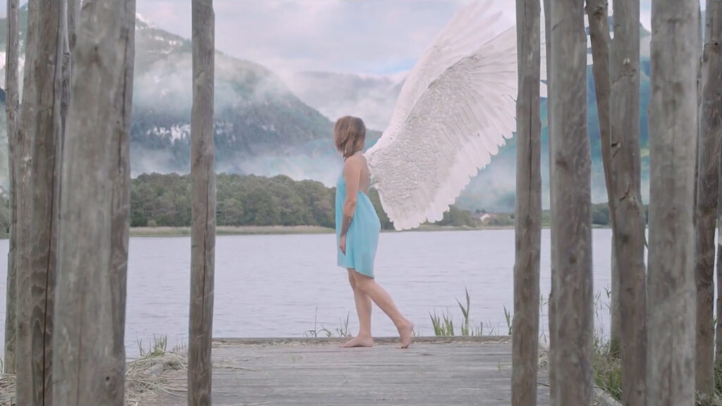 Femme avec des ailes, bord de l'eau, montagnes